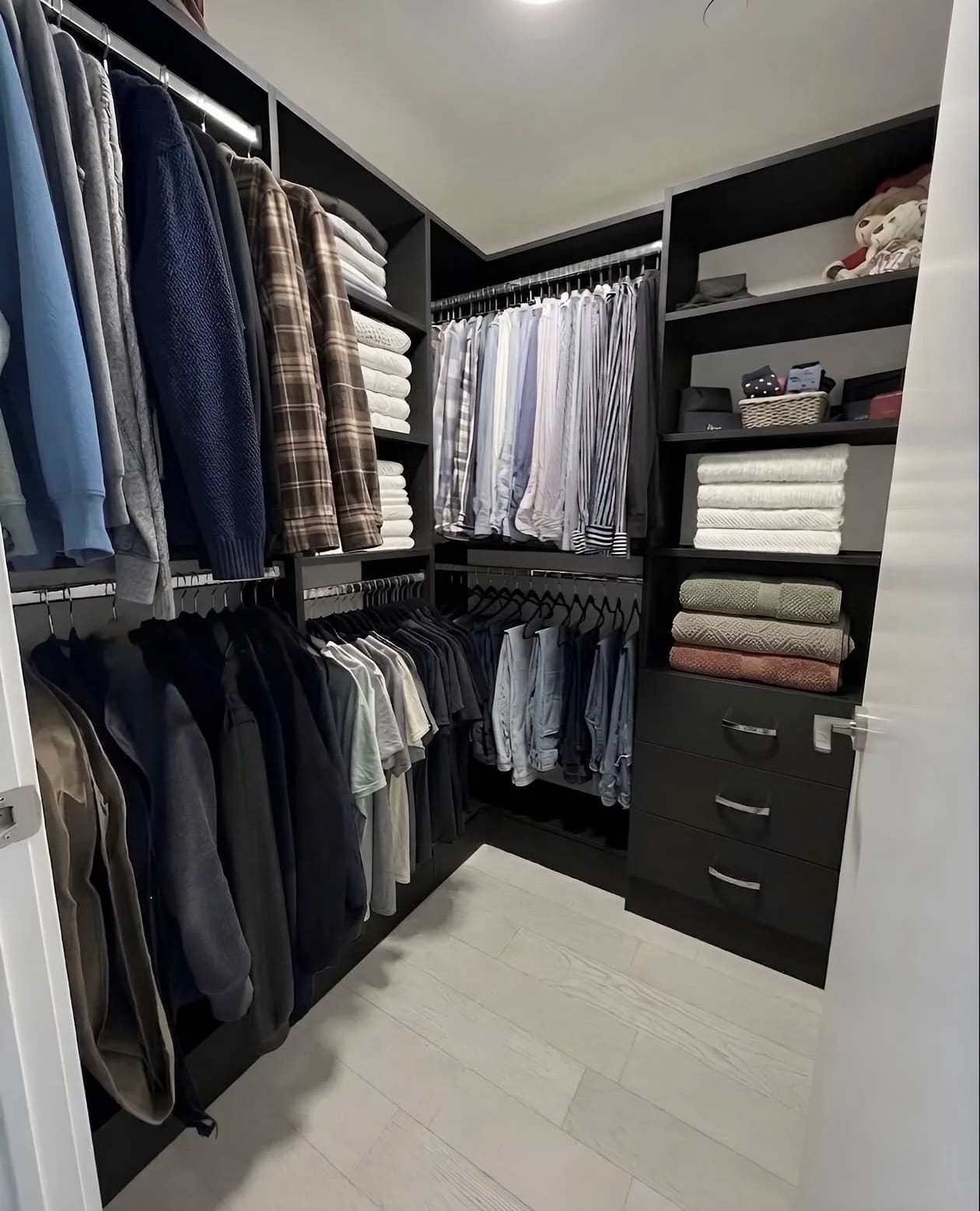 Espresso-finish walk-in closet with double hanging rails, folded shelving and a black drawer unit